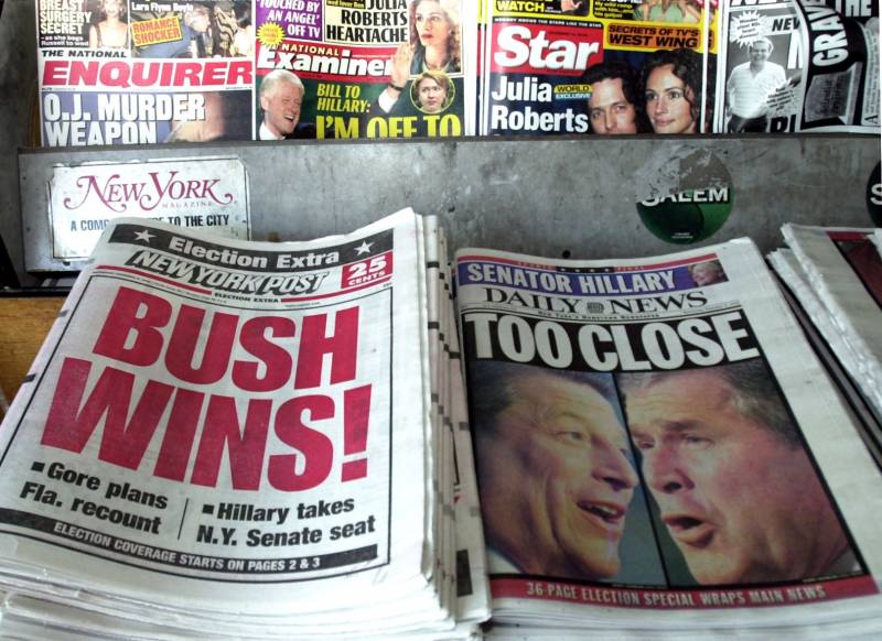 Newspapers sit side by side at a newstand. 'The New York Post' proclaims Texas Gov. George W. Bush the winner of the presidential election, while the 'New York Daily News' says the election is 'Too Close.' November, 2000.