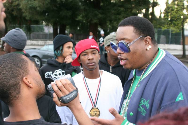 Jesus El stares into the camera as I video interview E-40 at Youth Uprising in Deep East Oakland.