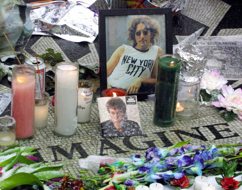 One of Bob Gruen's iconic John Lennon photos is seen amongst flowers and candles at the Central Park memorial to the Beatle, December 2000.