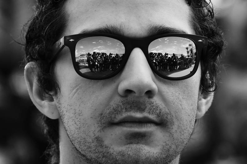A close-up image of Shia LaBeouf wearing sunglasses at the 69th Cannes Film Festival in 2016.