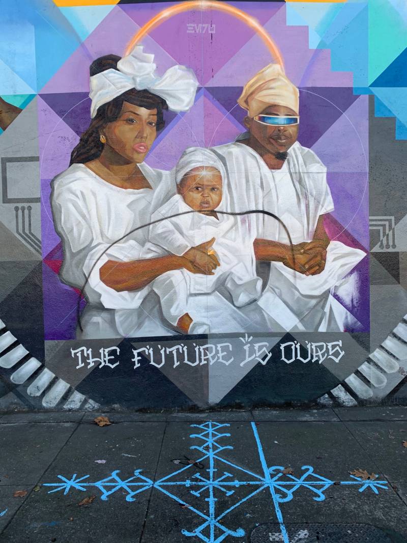 A line is shown, drawn though an image of the Black family at the center of the mural on 14th st. in West Oakland