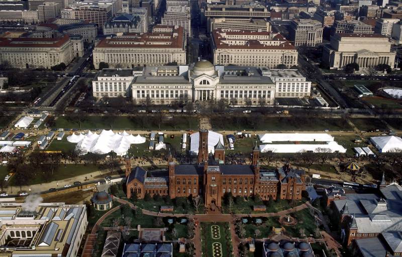 An aerial view of the National Mall in Washington, D.C., with the Smithsonian Institution Building ("The Castle") in the foreground and the Smithsonian's National Museum of Natural History in the background.