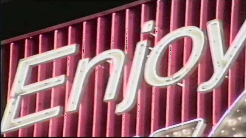 'Enjoy,' written and directed by Gordon Winiemko and Julie Wyman, utilizes the now-dismantled Coca-Cola sign to examine consumer culture.