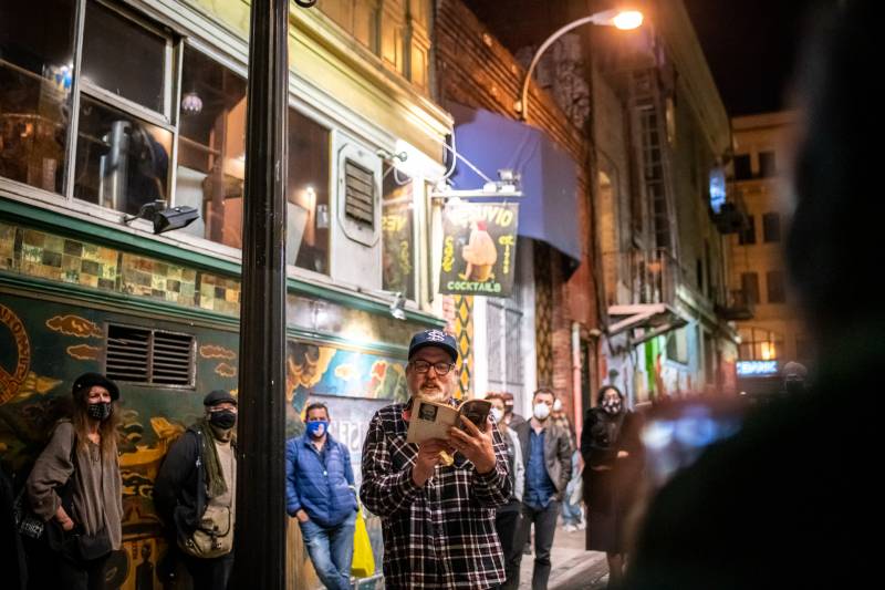 Poet Charlie Getter reads from Lawrence Ferlinghetti's book Coney Island of the Mind during a vigil outside of City Lights Books on Feb. 23, 2021.