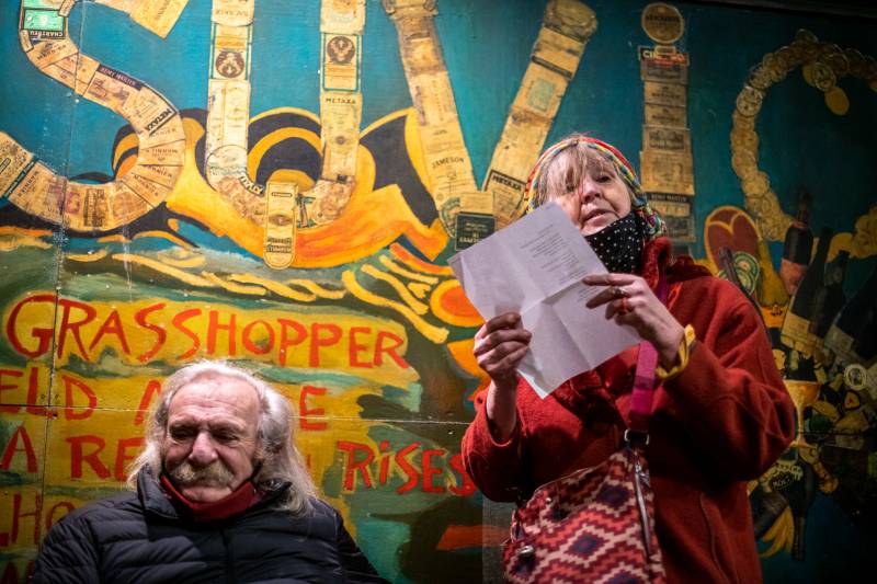 Agneta Falk reads a poem while Jack Hirschman listens during a vigil for Lawrence Ferlinghetti outside of City Lights Books on Feb. 23, 2021.