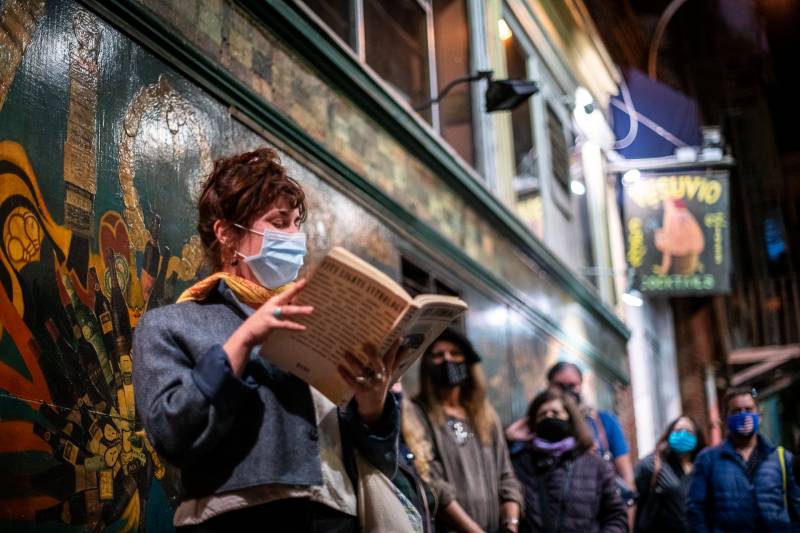 Hannah Forrester reads from a 1974 City Lights Anthology during a vigil for Lawrence Ferlinghetti outside of City Lights Books on Feb. 23, 2021.