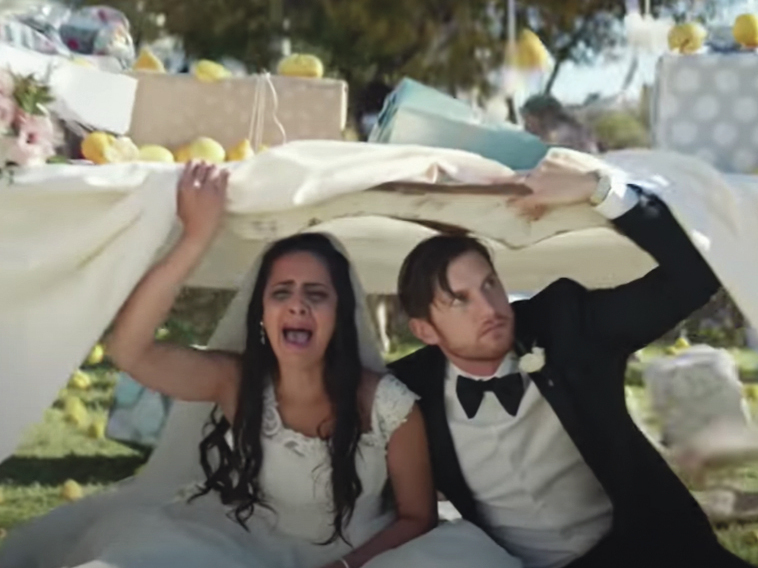A bride and groom hide under a table in Bud Light's "Lemons" Super Bowl Ad.