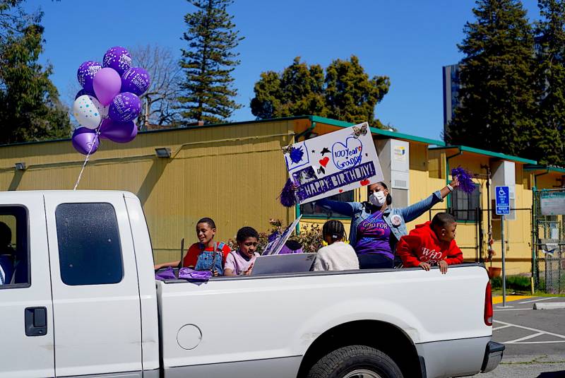 A pickup truck full of family members drives in the parade to celebrate Marcella Hubbard's 100th birthday. 