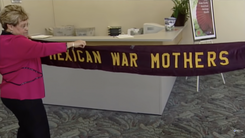 Enriqueta Andazola's granddaughter Diana Salgado Zuñiga unfurls a vintage 'Mexican War Mothers' banner, during KVIE documentary, 'Valentia: Mexican-Americans in World War II.' 