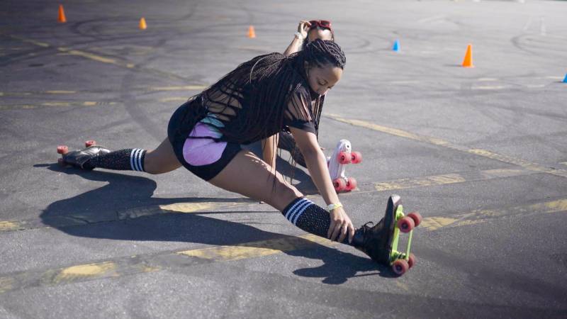 Roller skater Raqual "Roxy" Young doing splits on the pavement