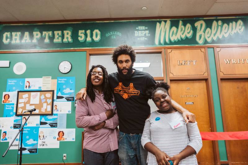 San Francisco Poet Laureate Tongo Eisen-Martin stands in the middle of Elijah and Amaya at Oakland's Westlake Middle School