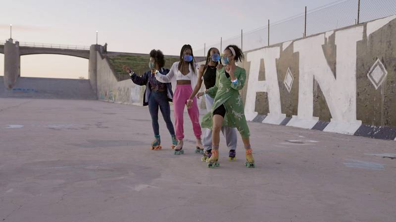Four roller skaters posing together at dusk at the Sepulveda Dam in Los Angeles, CA