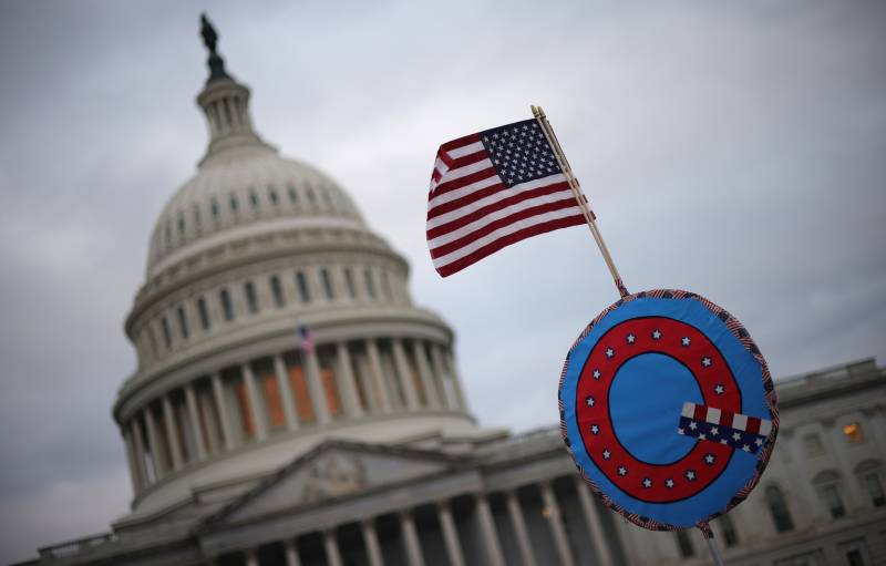 Supporters of then-President Donald Trump fly a U.S. flag with a symbol from the QAnon conspiracy theory as they gather outside the Capitol on Jan. 6 ahead of the insurrection.