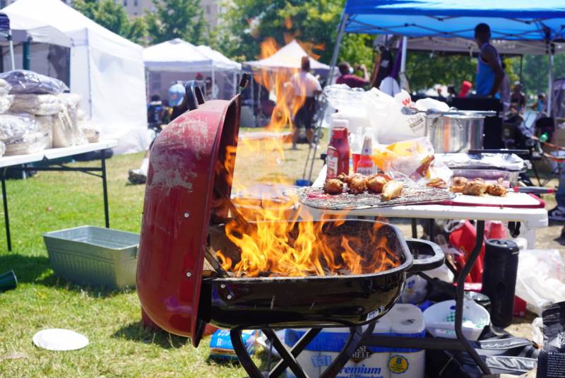 A barbecue grill is engulfed in flames near Lake Merritt as people celebrate Juneteenth in Oakland
