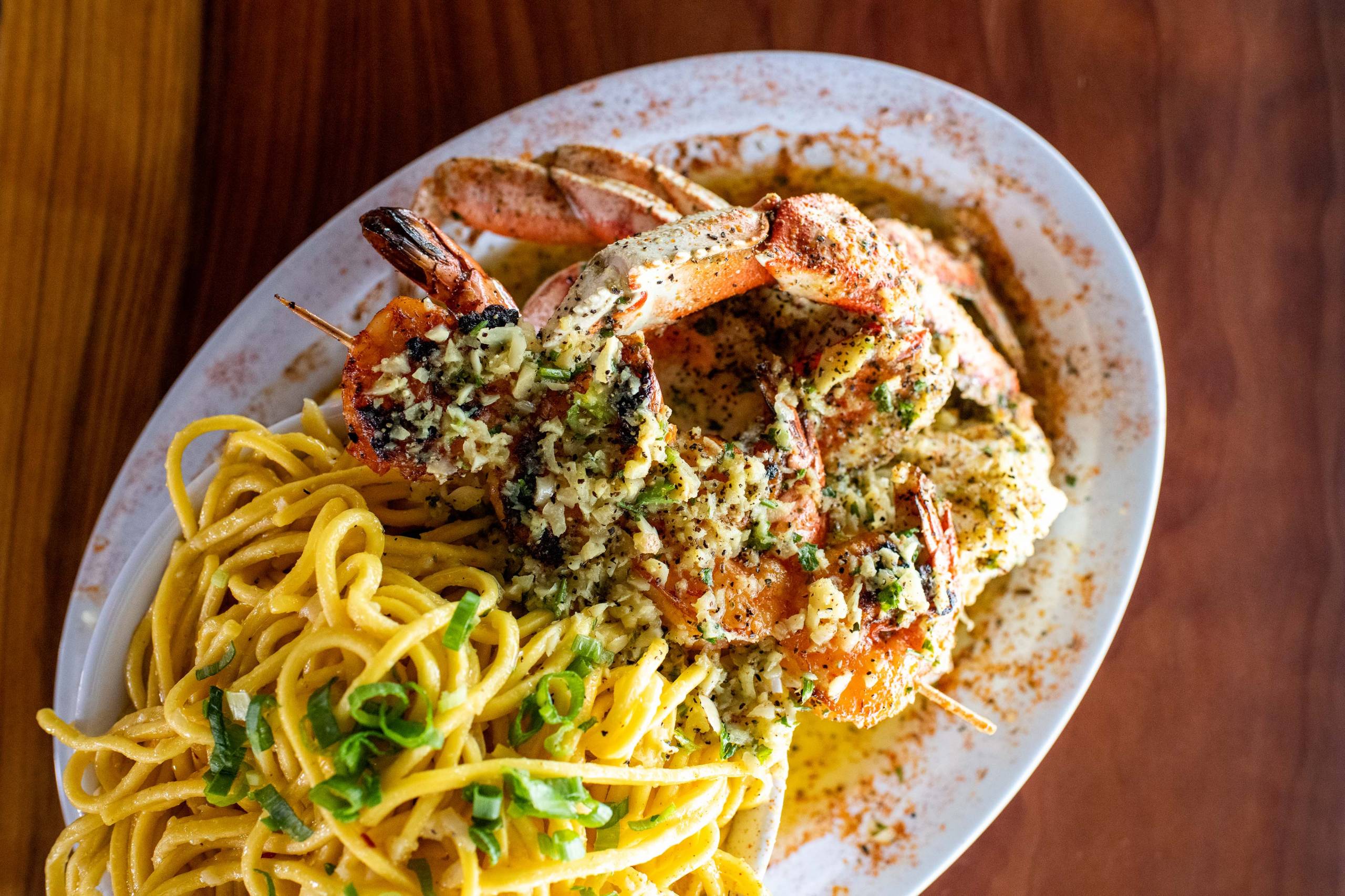Overhead view of a plate of garlic noodles and roast crab.