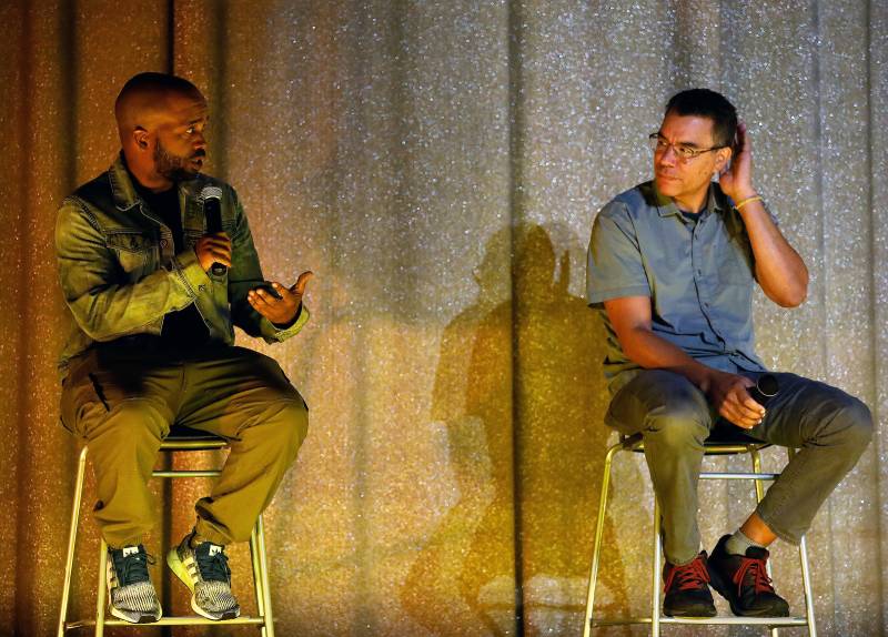 Pendarvis Harshaw and Pete Nicks sit in chairs on stage at Oakland's Grand Lake Theatre discussing the film Homeroom.