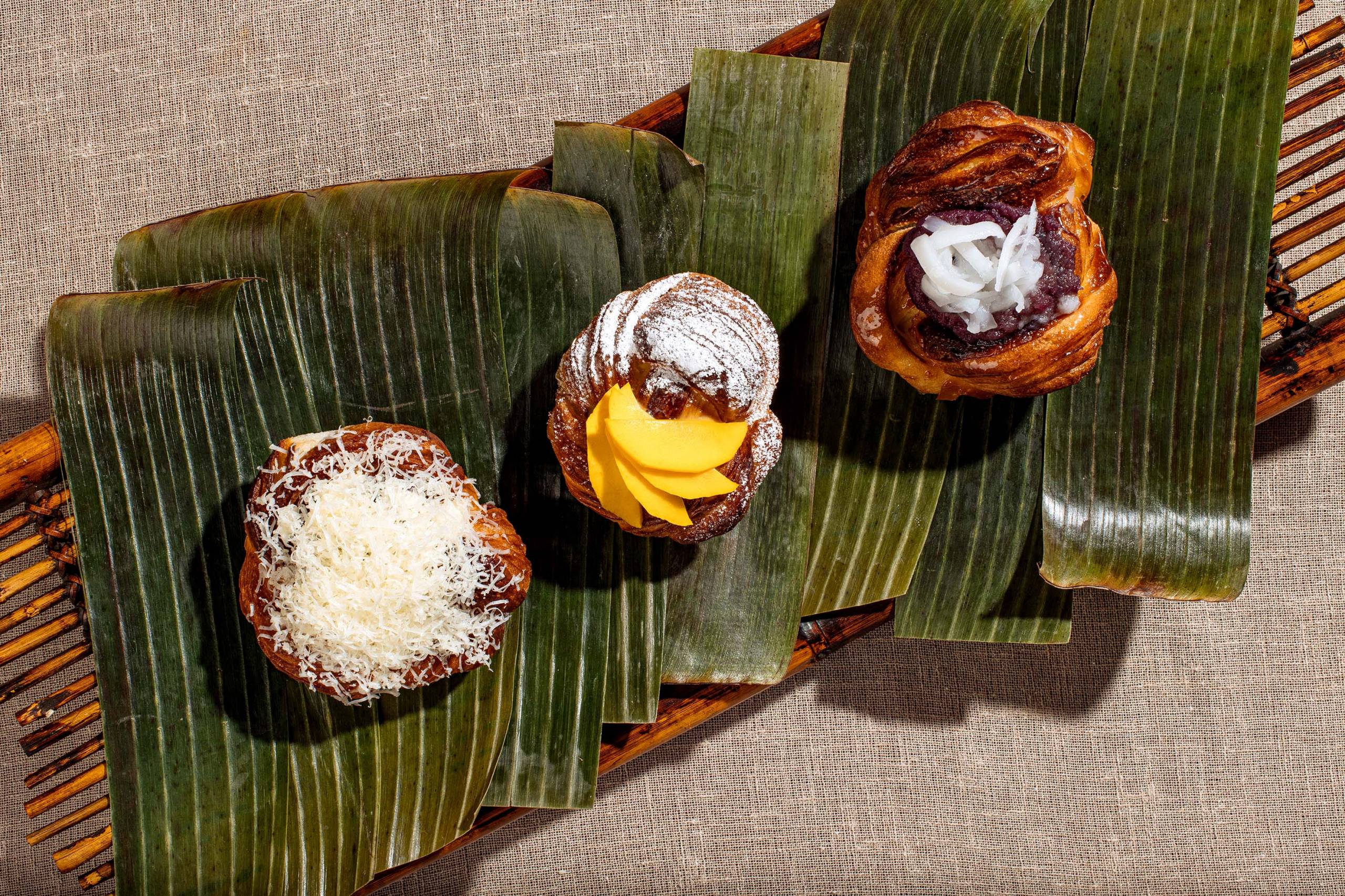 A trio of Filipino pastries, plated on top of banana leaves