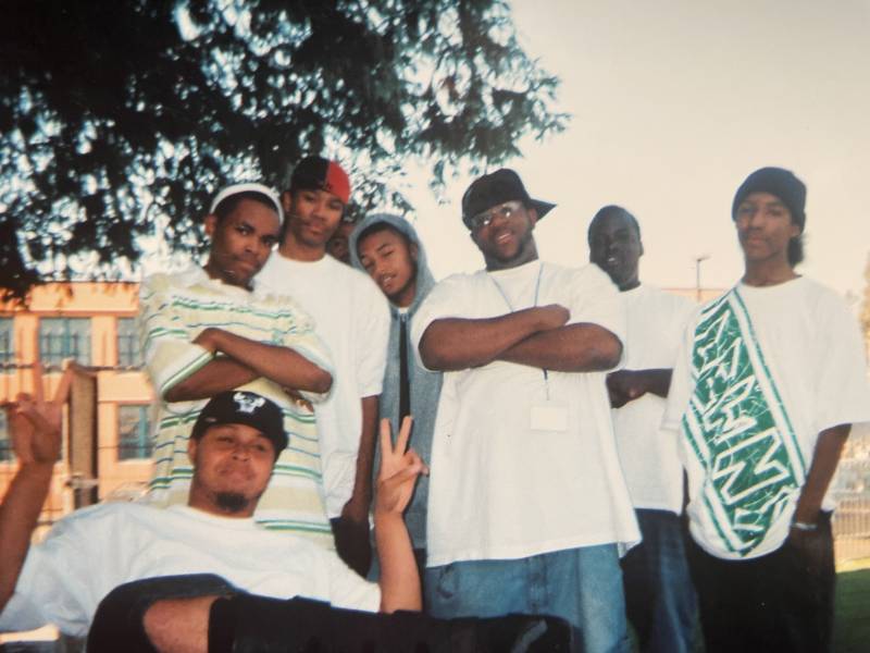 Raka Rich (center in the grey hoodie) stands with a number of young artists outside of East Oakland's Youth Uprising (circa 2005). 