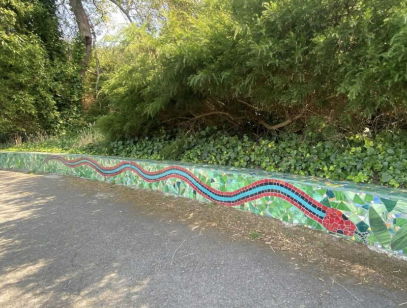 A blue and red mosaic depicting the gartersnake, against a green background.