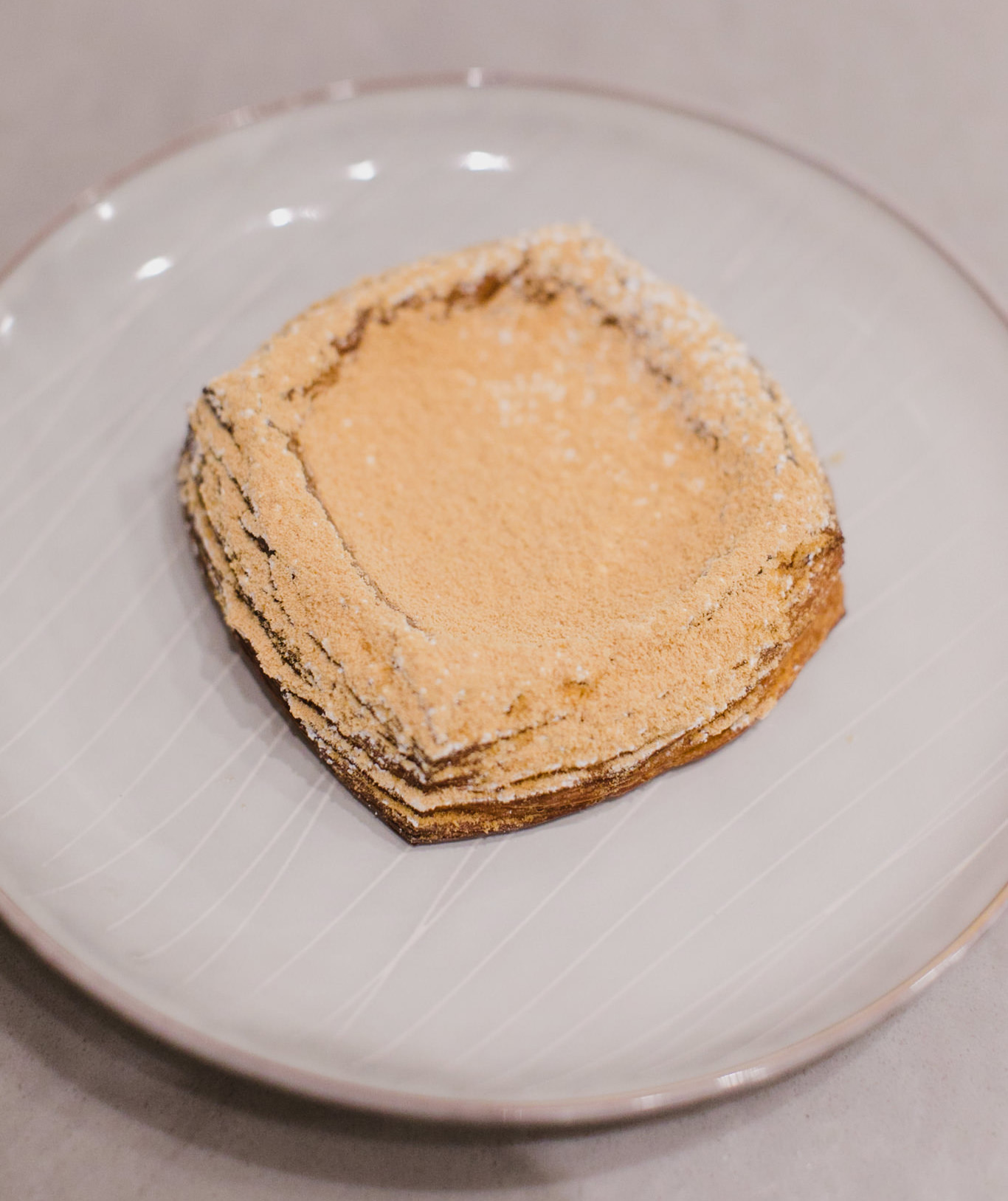 A square croissant topped with stretchy Korean rice cake dusted with roasted soybean poweder.