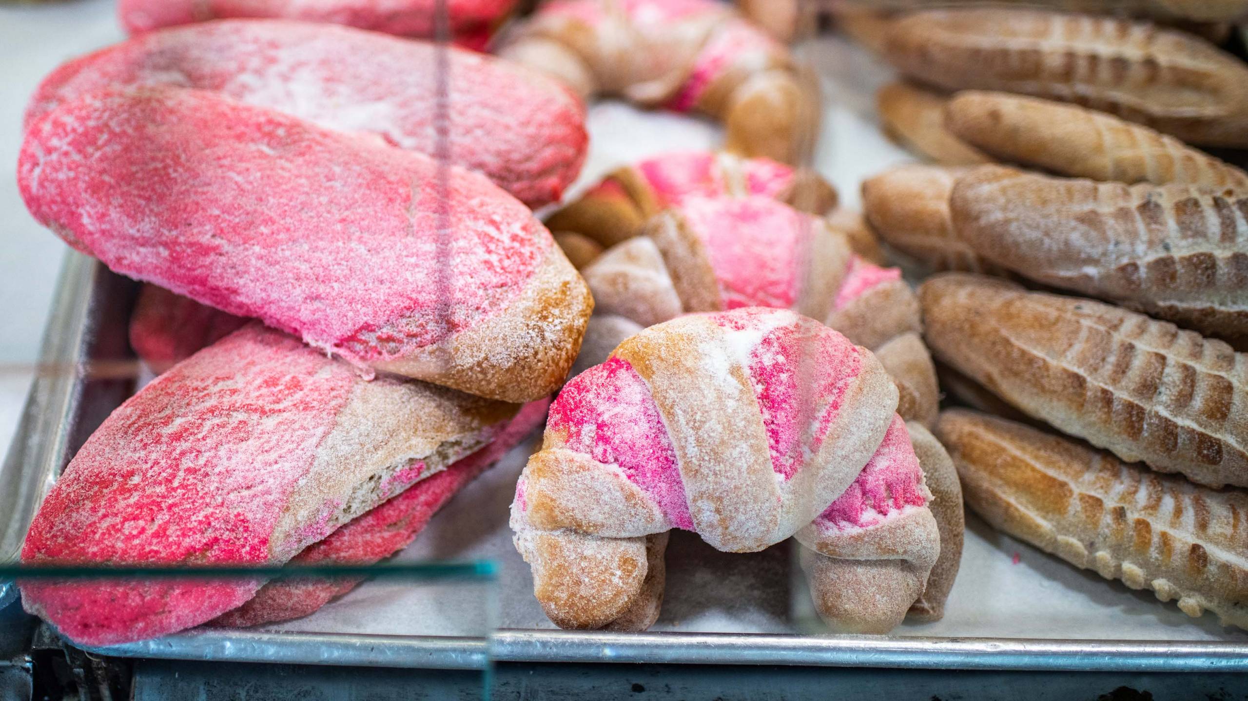 A display case full of colorful pink pastries.