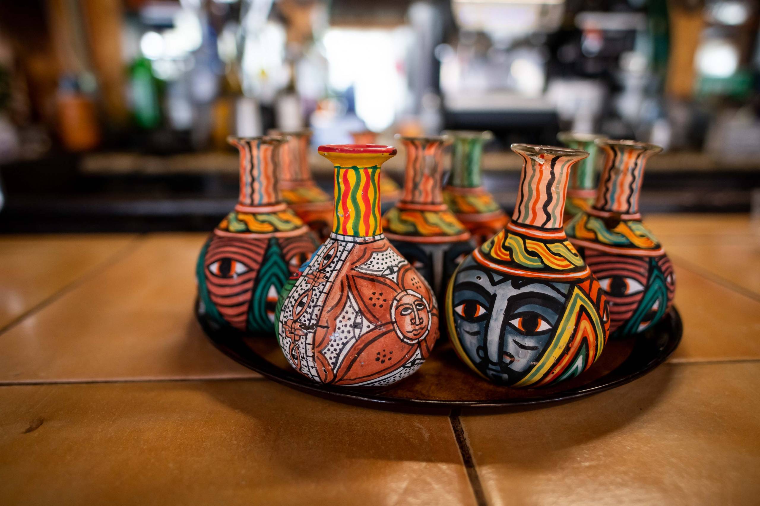 Colorful, long-necked painted bottles arranged on a countertop.