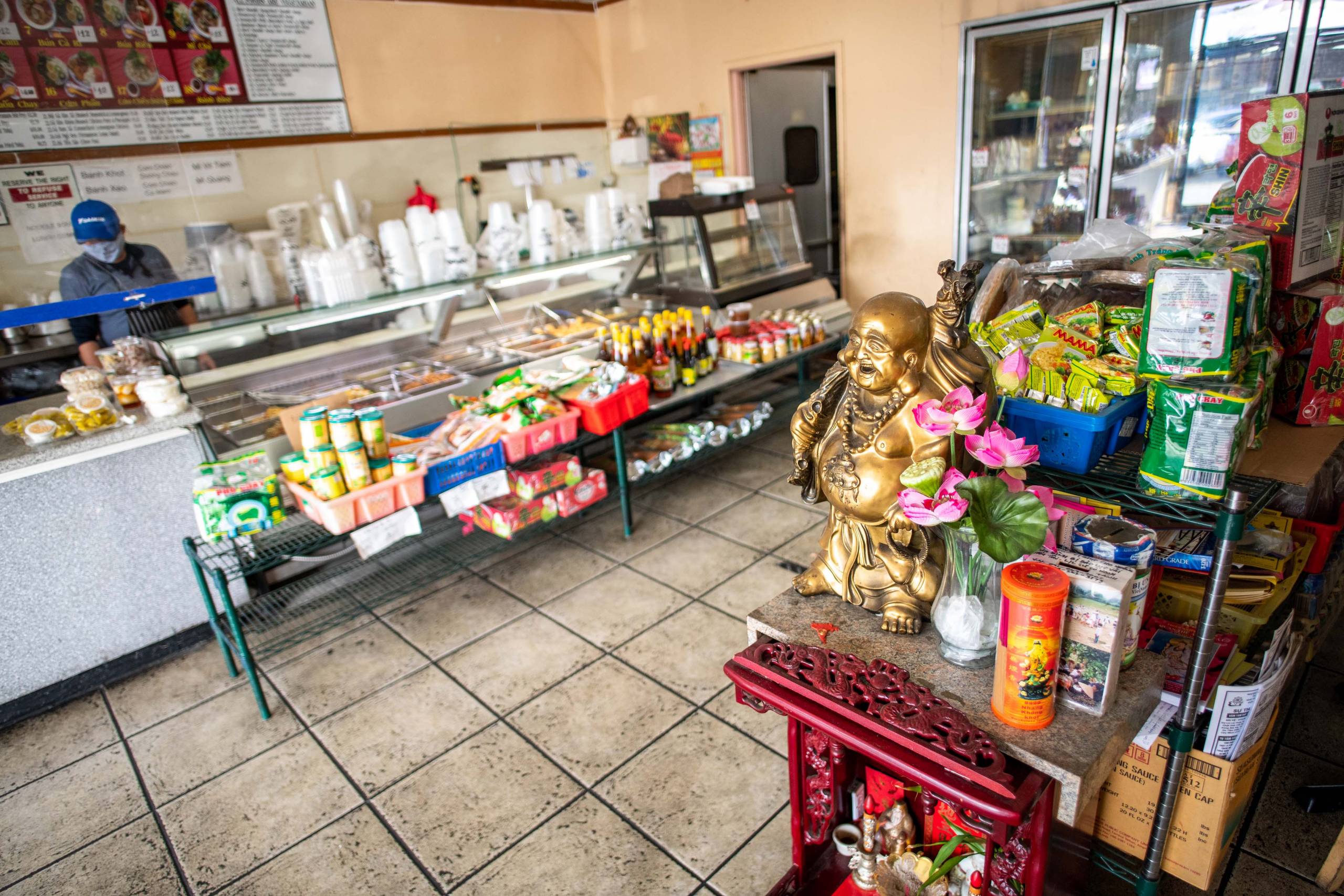 A Buddha statue is displayed prominently inside a Vietnamese deli.