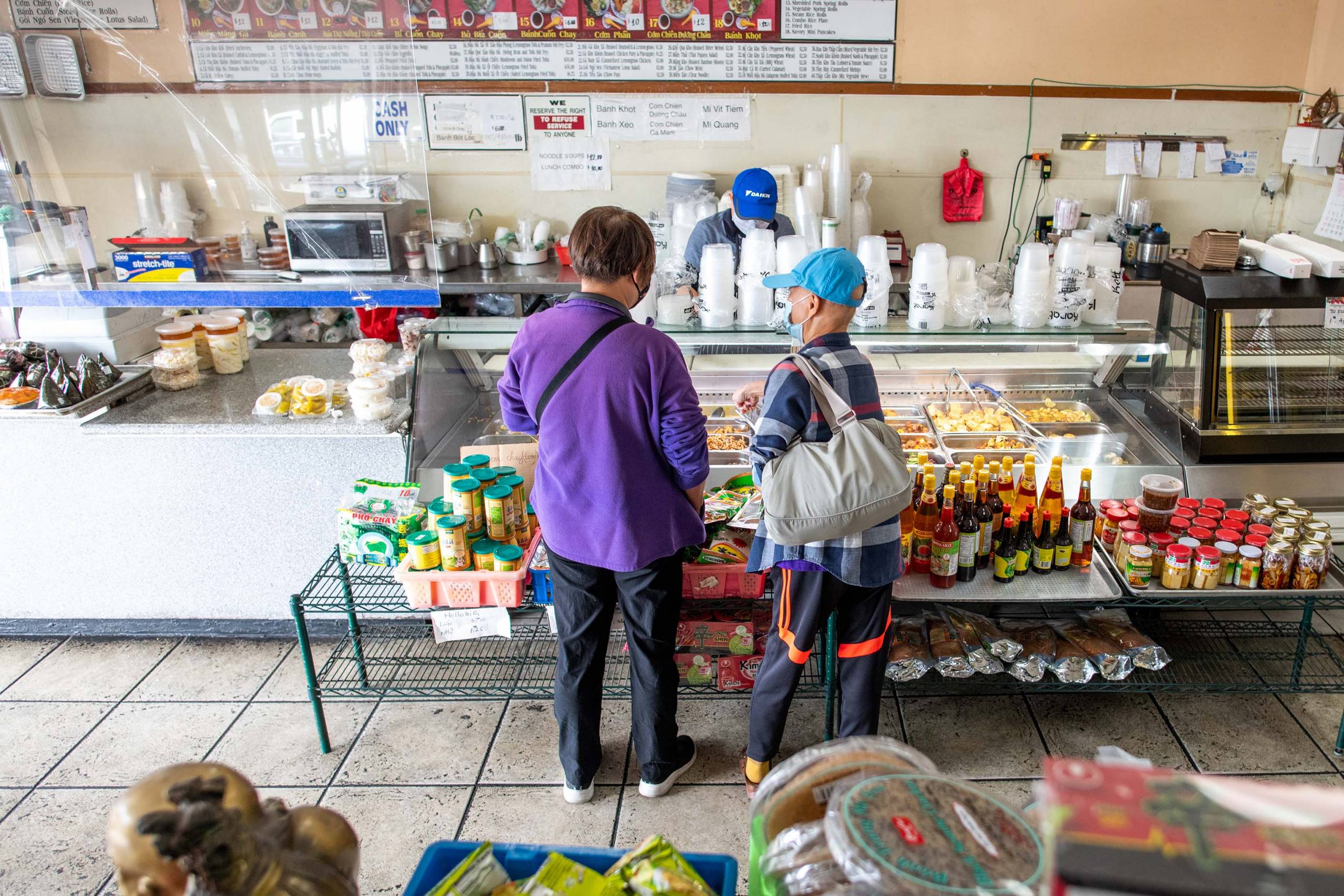 Two customers browse the display of goods inside a Vietnamese deil.
