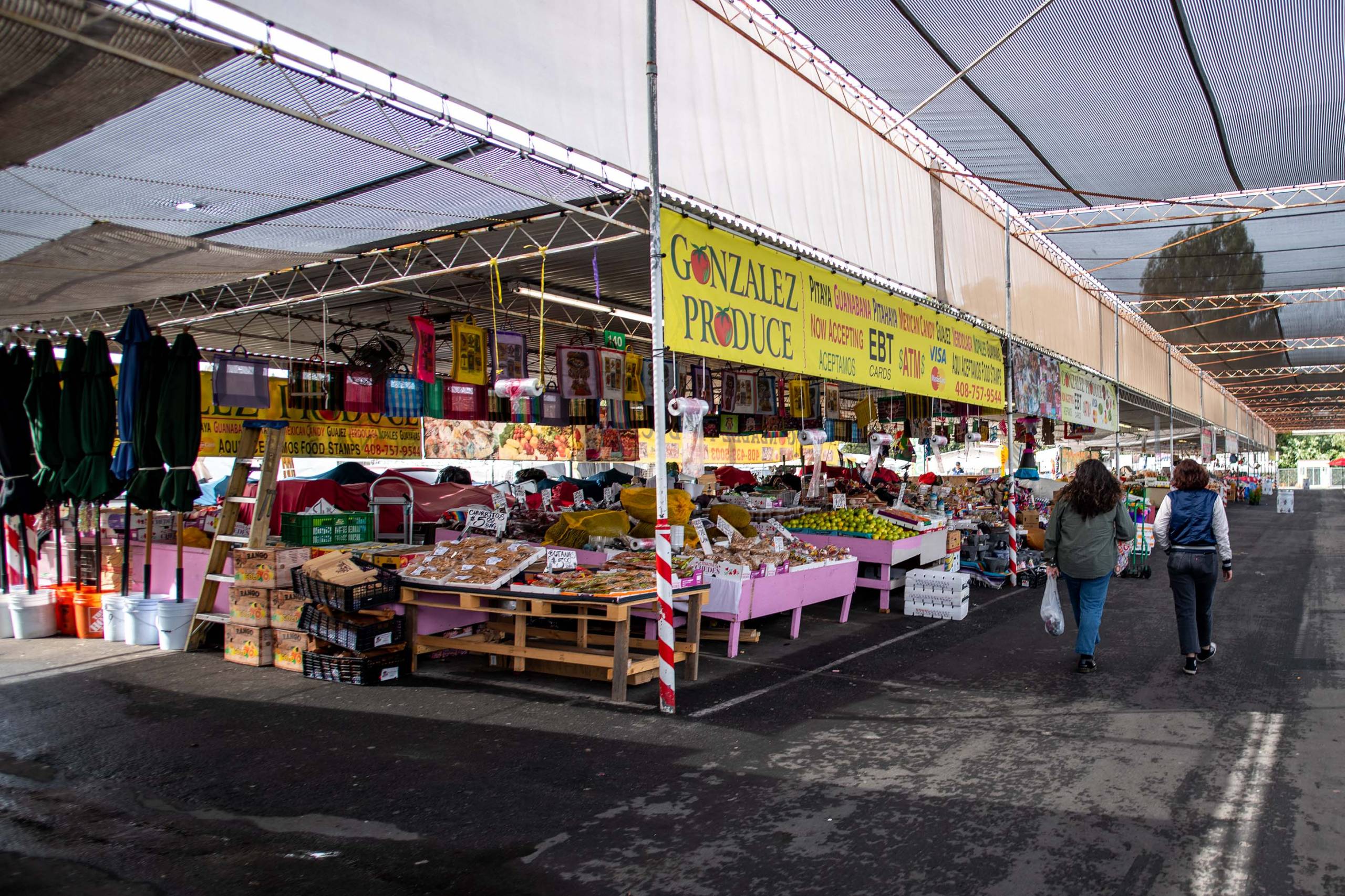 A row of open-air produce stands.