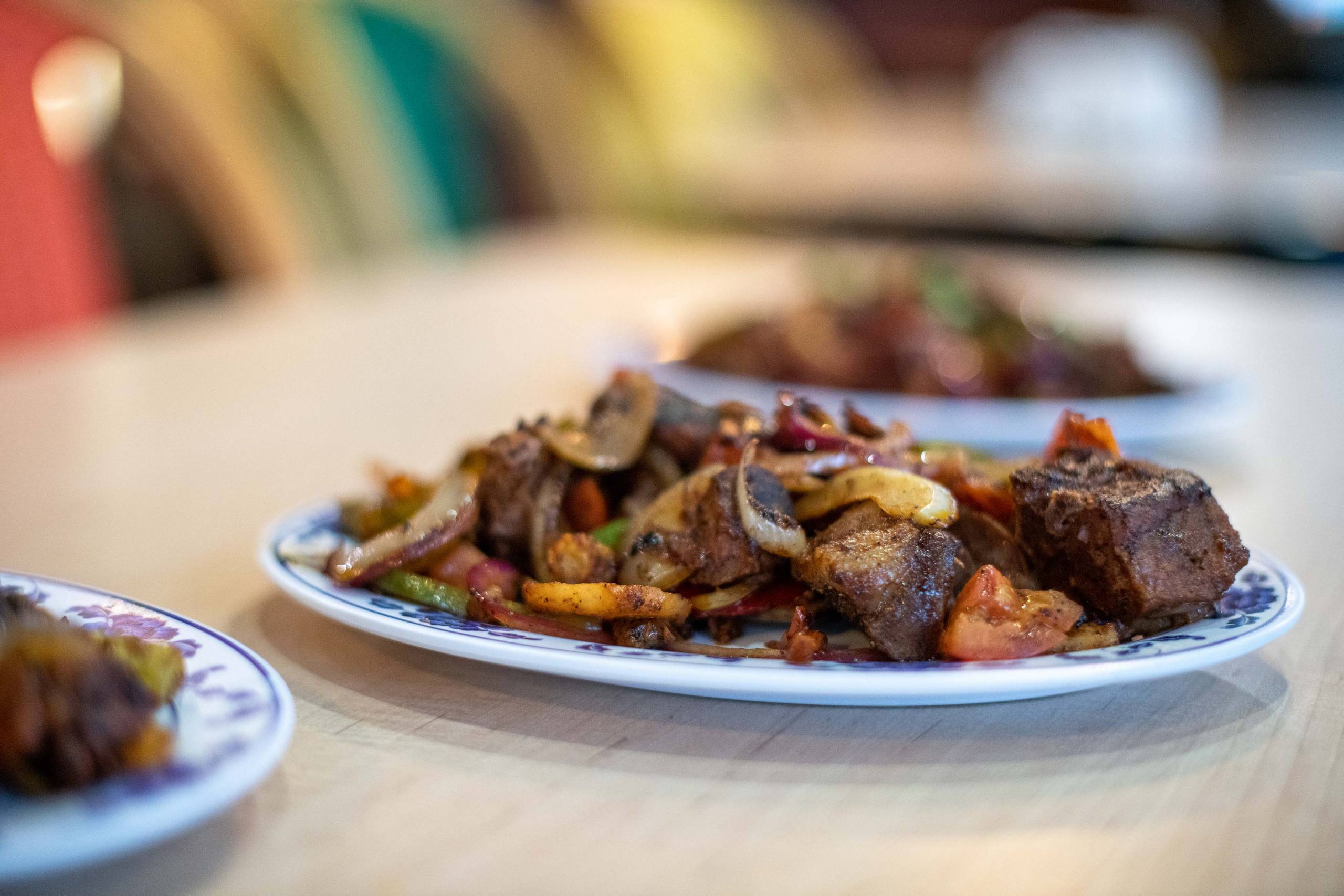 A plate of Somali-style goat suqaar—a kind of stir-fry—on a table.