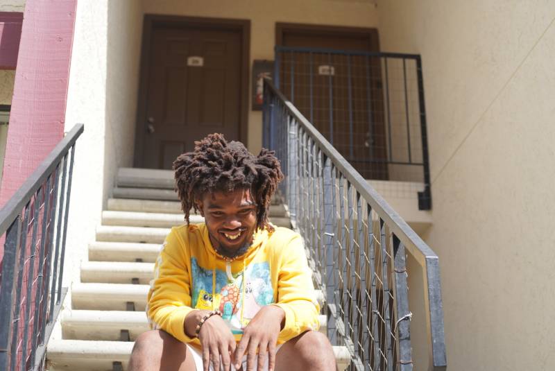 Infamous TAZ cracks a smile as he sits on the staircase in front of his old apartments in Pittsburg.