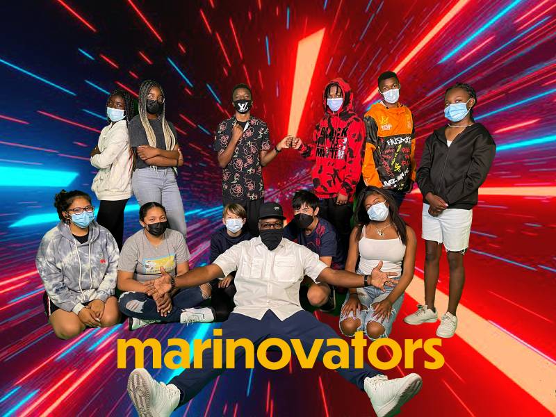 The Marinovators and MC Jahi wear masks as they pose for a photo.