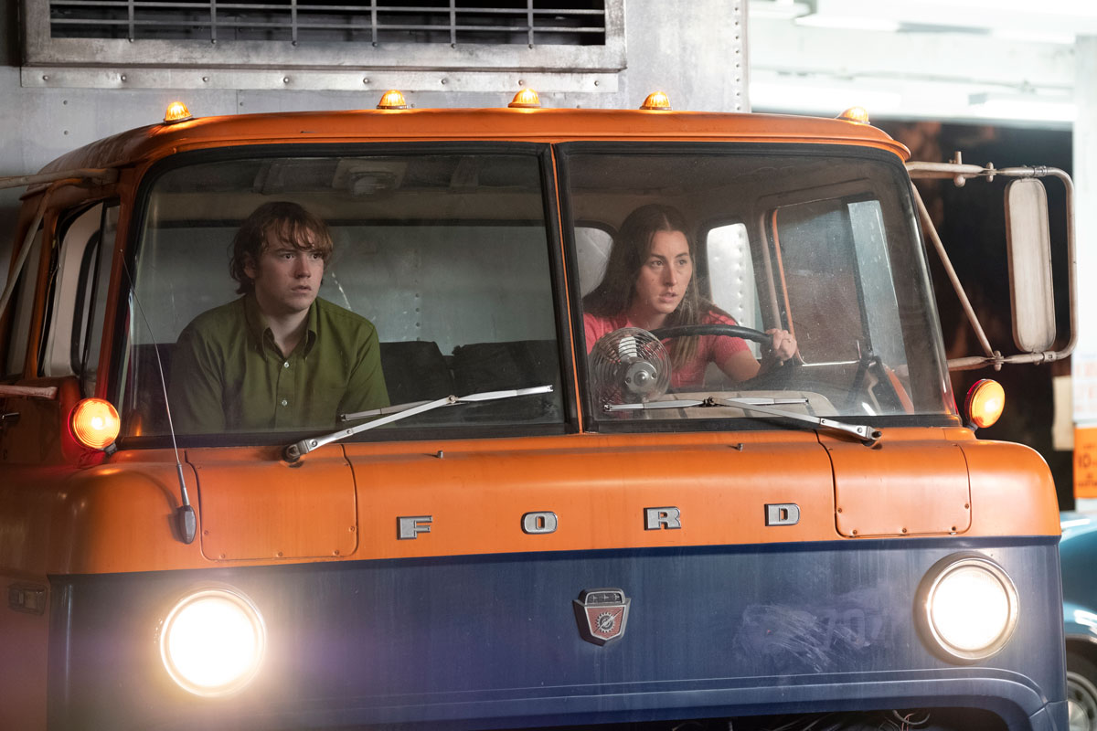 Young man and woman driving a Ford truck, looking stressed.