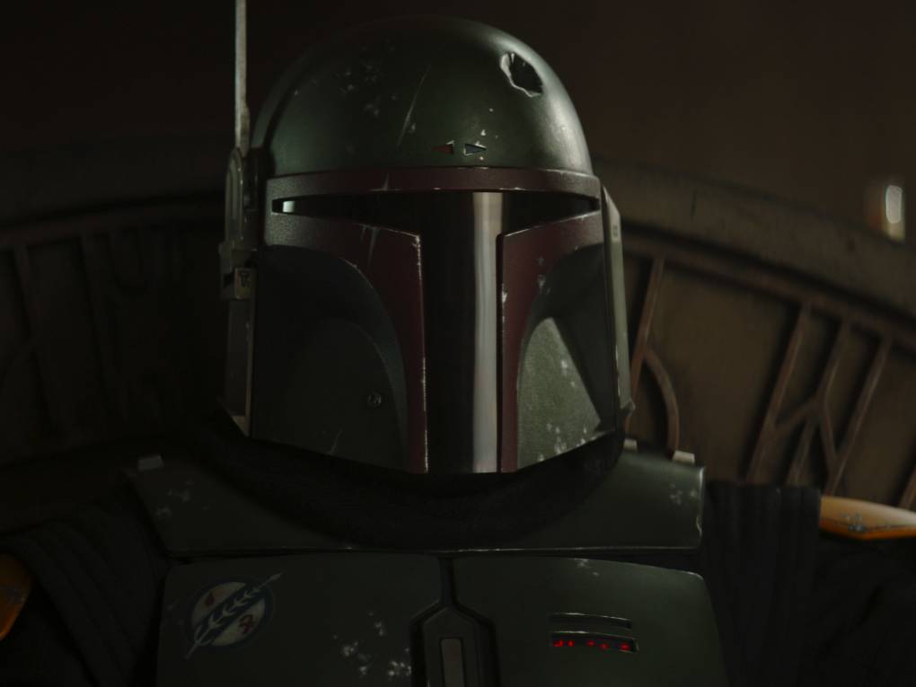 A close up of Boba Fett wearing his iconic green and red helmet.