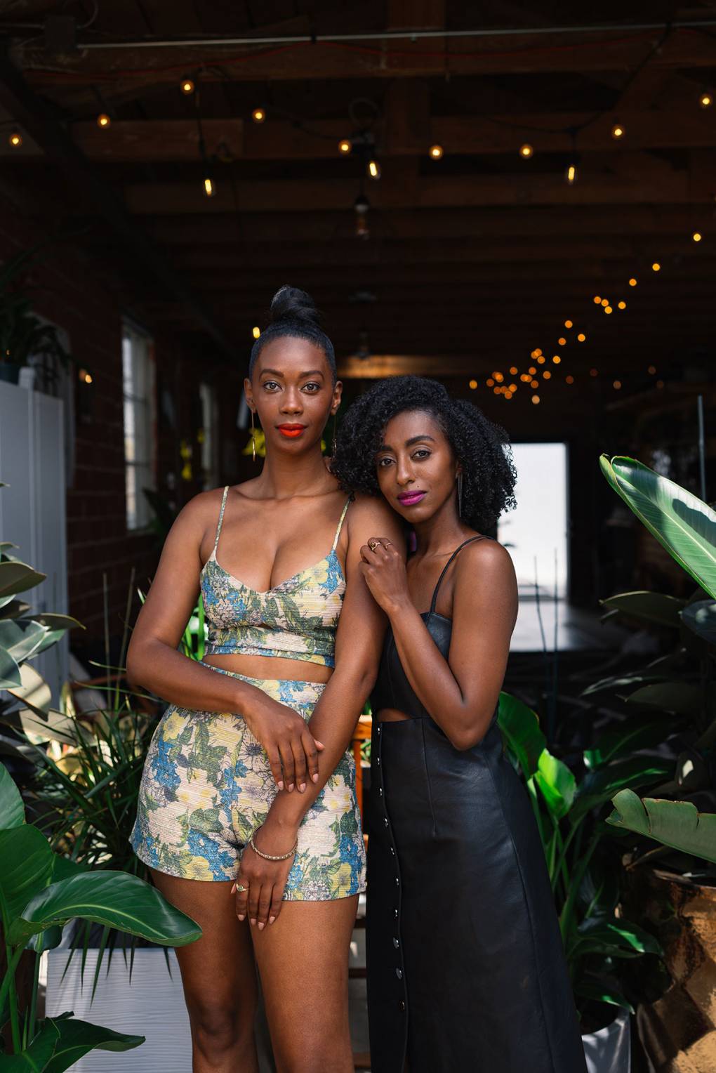 Two Black women standing side-by-side in a plant store