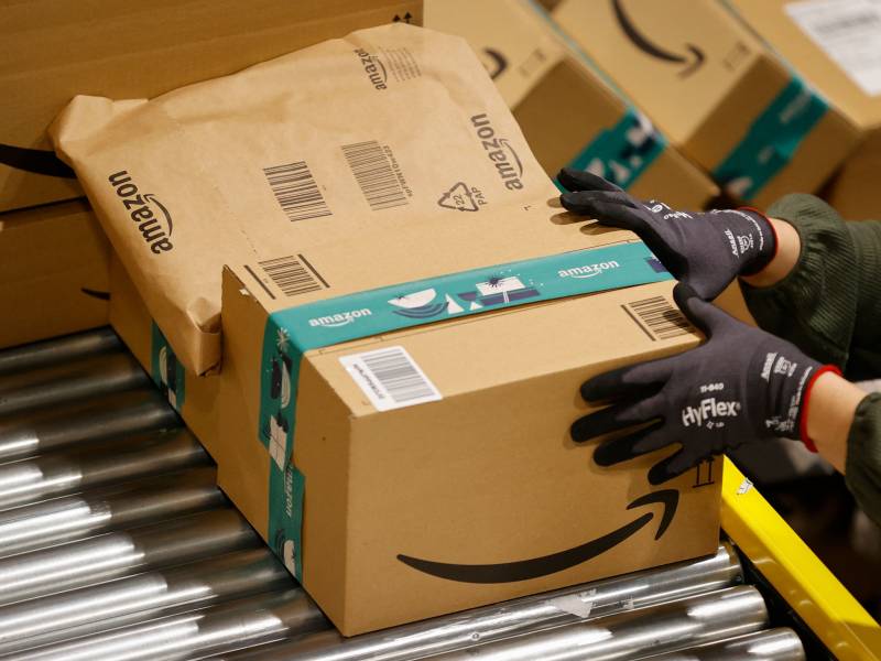 An employee handles packages at the Amazon's centre of Bretigny-sur-Orge, on December 14, 2021.