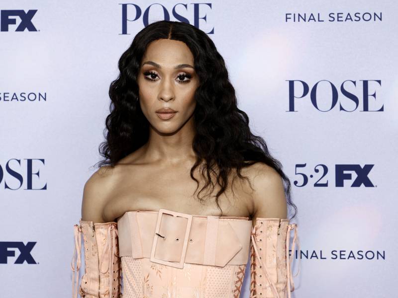 Rodriguez strikes a pose on the red carpet, wearing a peach colored corset and long gloves. Her long dark hair falls in waves over her shoulders.