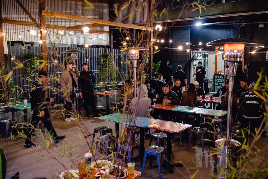 Customers mingle on a bar's outdoor patio.