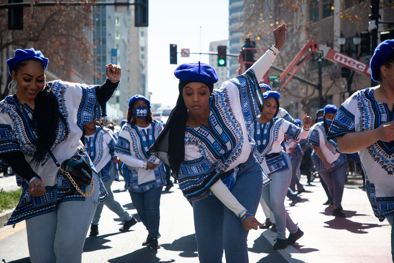 A dance group in matching blue dashiki outfits