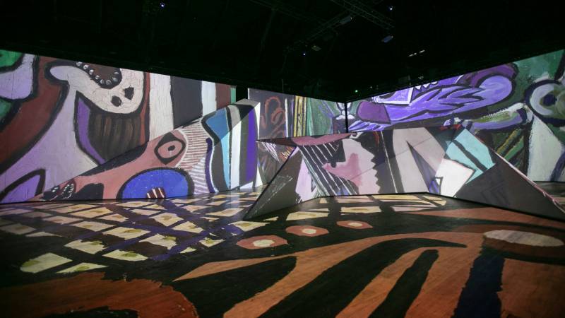 Projected fragments of colorful paintings on walls and floor