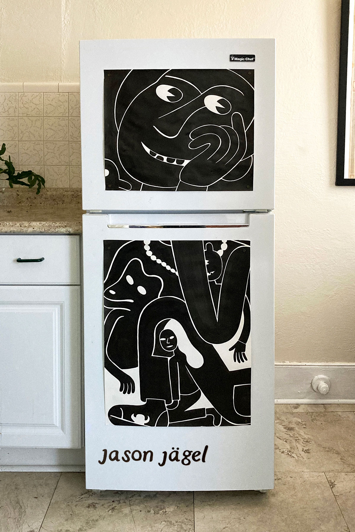 Two black and white drawings on a fridge