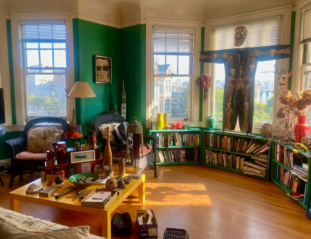 Spacious room with bay windows, lots of art and books