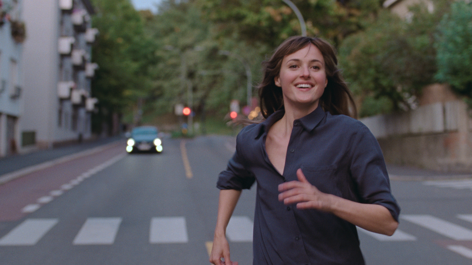 A woman runs in a street, smiling