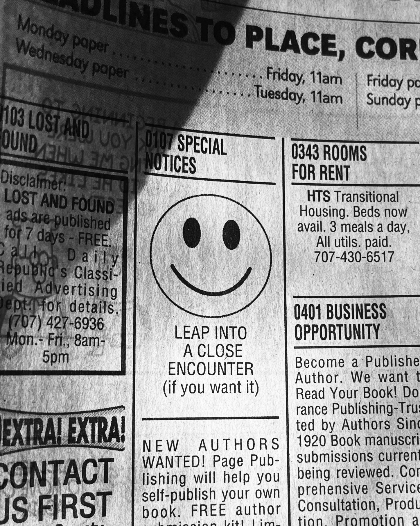 View of newspaper classified section with smiley face at center
