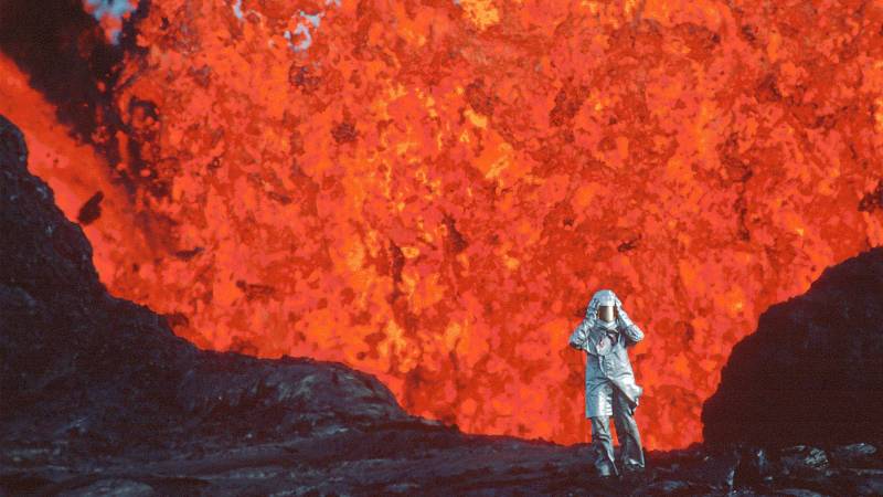 A person in a spacesuit-looking outfit in front of a giant fireball