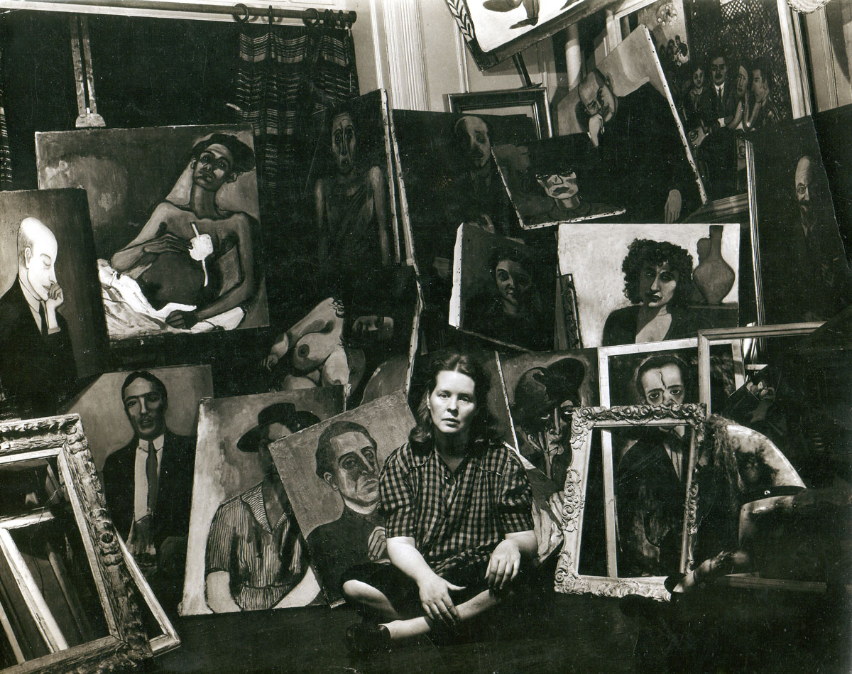 Black-and-white image of woman sitting on floor surrounded by paintings