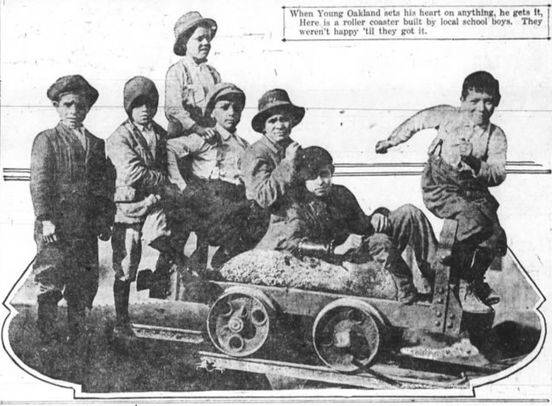 Seven children, most around the age of 10, all wearing white shirts, hats and suspenders, sit in a miniature railway car.
