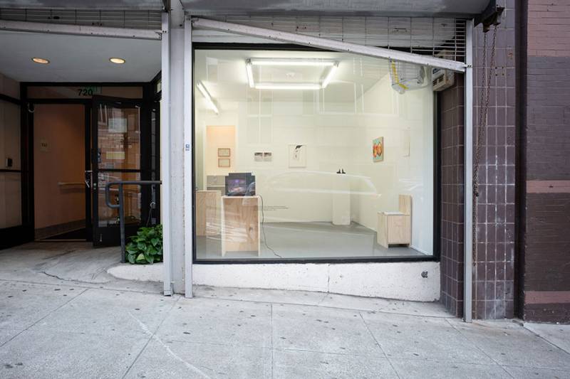 A street view of a small, one-rrom gallery with floor-to-ceiling windows