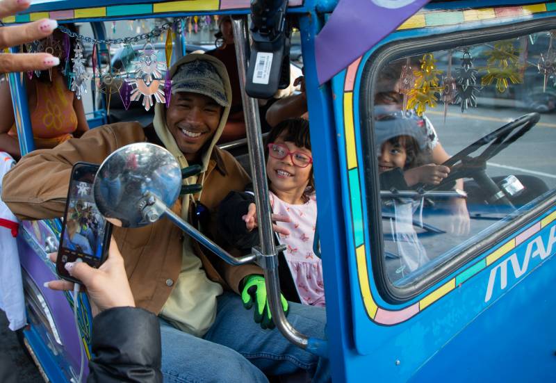 Toro y Moi poses with young fans in a colorful bus parked outside of FOB Kitchen in Oakland.