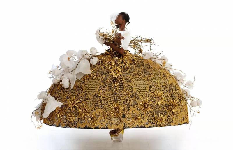 A Black woman in a large golden dress